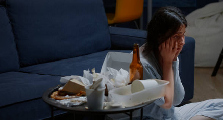 Girl stress-eating junk food during a weight loss plateau